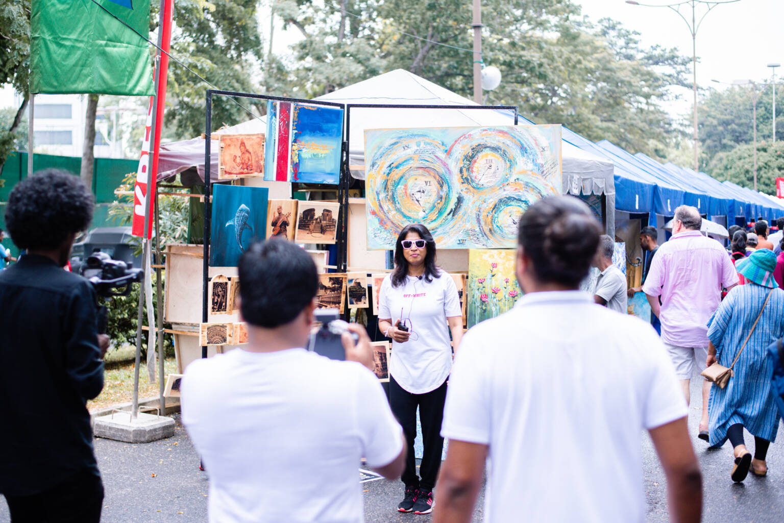 A woman is presenting the artwork to viewers nearby.